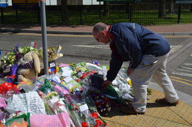 Community member leaves a flower bouquet for Drummer Lee Rigby 