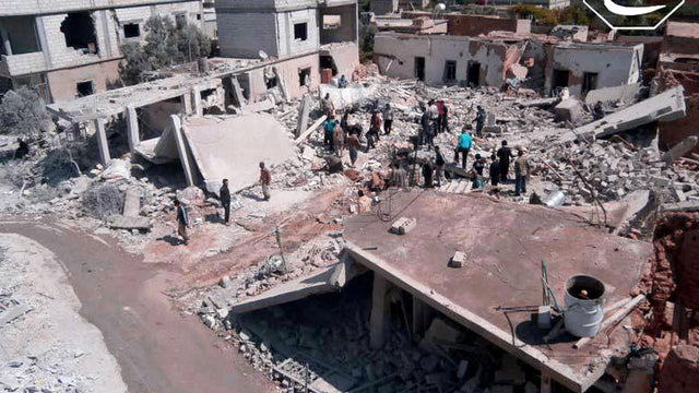 May 21, 2013 citizen journalism image provided by Qusair Lens, which has been authenticated based on its contents and other AP reporting, shows Syrian citizens gathering over houses that were destroyed by Syrian forces air strike in Qusair 