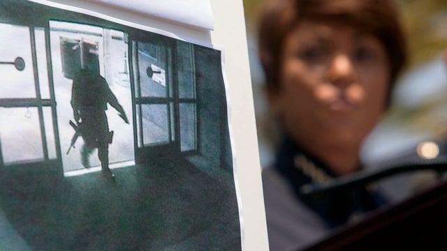 A picture of the suspect entering the Santa Monica College library is seen as Jacqueline Seabrooks, chief of the Santa Monica Police Department, speaks during a news conference June 8, 2013, in Santa Monica, Calif. 