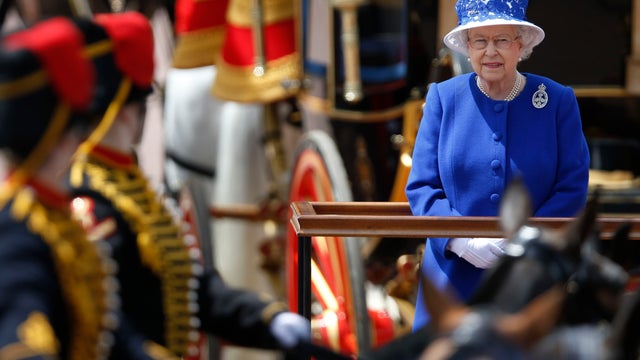 Britain's Queen Elizabeth II as the Guards march pass outside Buckingham Palace after the Trooping The Colour, at the Horse Guards Parade in London, June 15, 2013.  