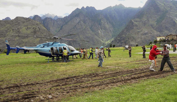 Rescuers help escort stranded pilgrims to helicopters to evacuate at Joshimath in the northern Indian state of Uttarakhand, India. 