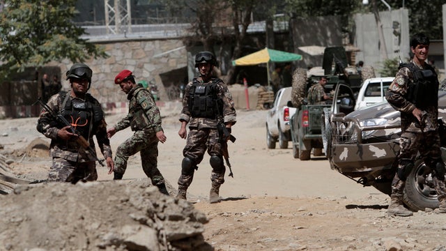 Afghan security force members investigate near entrance gate of presidential palace in Kabul, Afghanistan June 25, 2013 