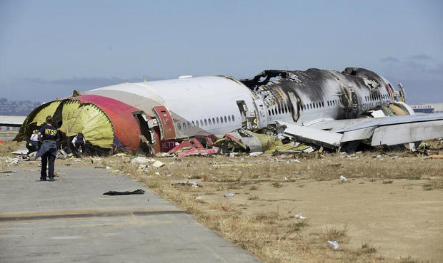NTSB officers examine the scene of an Asiana Airlines crash at San Francisco International Airport in photos released Sunday, July 7, 2013. 