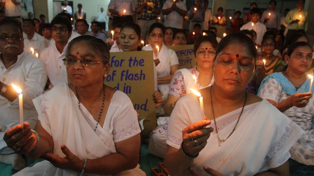 Indians hold candles as they pray for the victims of Uttarakhand floods at a temple in Ahmadabad 