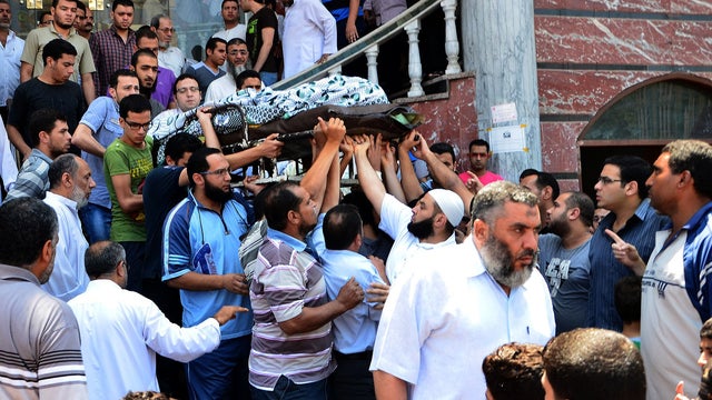 Egyptian people carry the body of a victim of the clashes that broke out between supporters and opponents of Egypt's depose president Mohamed Morsi during a funeral ceremony on July 20, 2013 in the Nile delta city of Mansura.  
