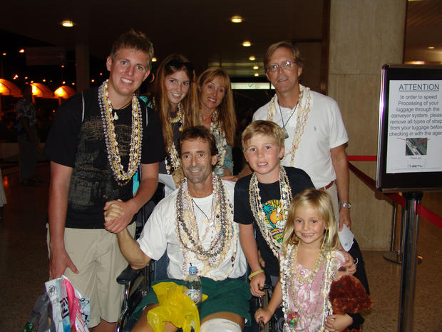 John Silverwood surrounded by his family leaving Tahiti-Faa'a International Airport for transport back to Los Angeles. They are wearing traditional Polynesian shell leis given to them by the members of the French Navy, who saved their lives. 