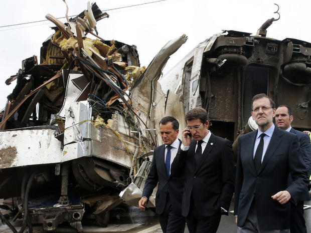 Spanish Prime Minister Mariano Rajoy, right, and Galicia's regional president, Alberto Nunez Feijoo, second left, visit the site of a train accident near the city of Santiago de Compostela, Spain, July 25, 2013. 