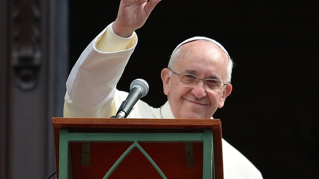 Pope Francis waves at the crowd from a balcony of the San Joaquin Episcopal Palace in Rio de Janeiro after delivering the Angelus prayer July 26, 2013. 