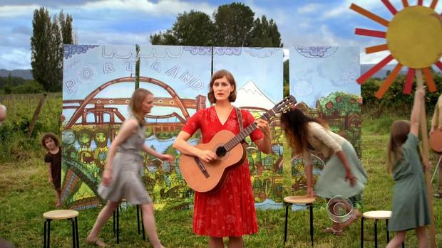 A woman plays a guitar in this quirky video about Oregon's new healthcare marketplace, Cover Oregon. 