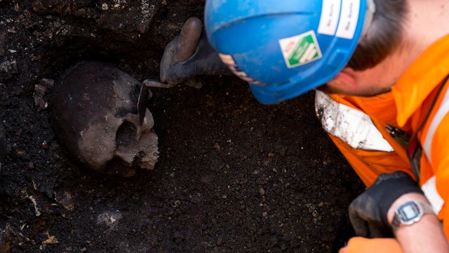 A skull is revealed as an archaeologist digs on a site near London's Liverpool Street railway and tube station 