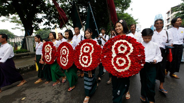 Members of Myanmar's prominent 88 generation students group hold wreaths during a march to mark the 25th anniversary of Myanmar's pro-democracy uprising in Yangon, Myanmar. 