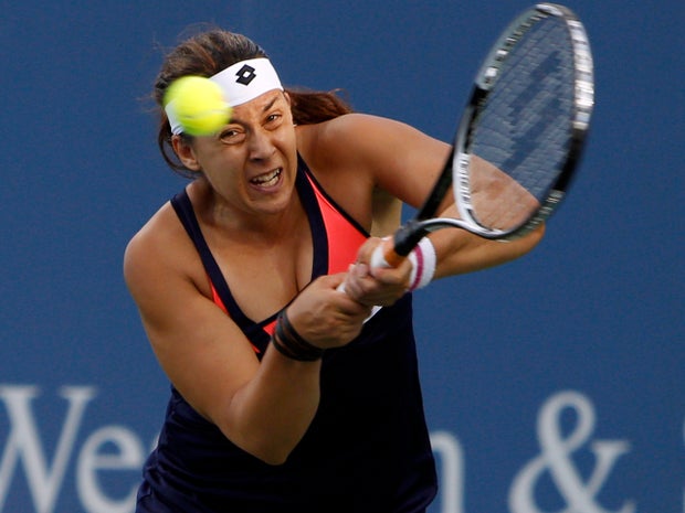 Marion Bartoli, from France, returns against Simona Halep, from Romania, during a match at the Western & Southern Open tennis tournament Aug. 14, 2013, in Mason, Ohio. 