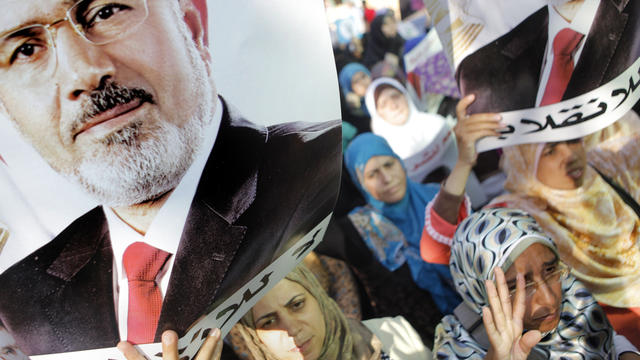 Supporters of ousted Egyptian President Mohammed Morsi hold posters with Morsi's face and words in Arabic that read "No to the coup" as they march in the Maadi district of Cairo Aug. 19, 2013. 