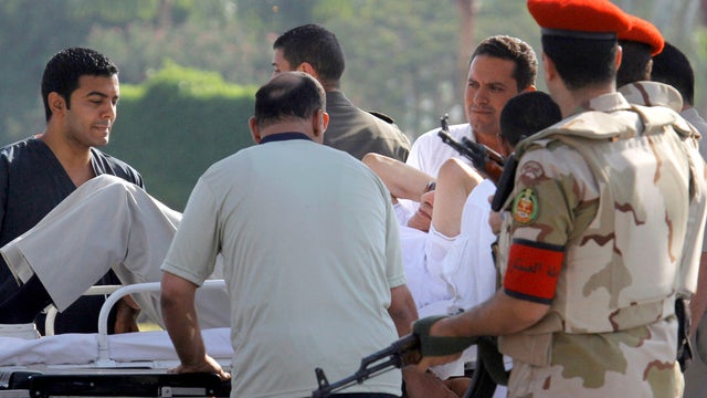 Egyptian medics and military policemen escort former Egyptian President Hosni Mubarak, 85, into an ambulance after he was flown by a medically equipped helicopter to the Maadi Military Hospital from Torah prison in Cairo Aug. 22, 2013. 