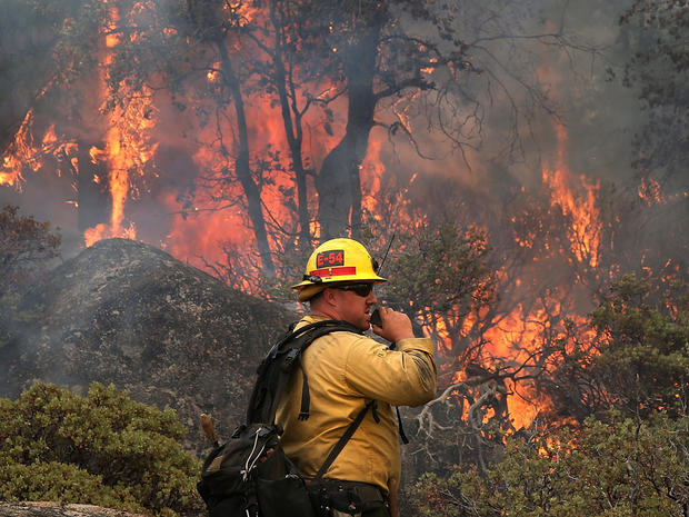 U.S. Forest Service firefighter Chris Brossard talks on his radio while monitoring a spot fire while battling the Rim Fire Aug. 24, 2013, in Yosemite National Park, Calif. 