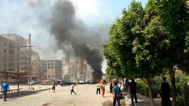Egyptian Interior Minister Mohammed Ibrahim, right, gives his condolences to a policeman during a military funeral in Cairo, Egypt. Aug. 15, 2013. 
