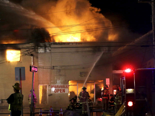 Firefighters battle a blaze in a building on the Seaside Park boardwalk on Thursday, Sept. 12, 2013, in Seaside Park, N.J. The fire began in a frozen custard stand on the Seaside Park section of the boardwalk and quickly spread north into neighboring Seaside Heights. 