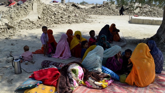 Pakistani villagers sit under tree near rubble of destroyed homes in remote district of Awaran, Baluchistan province, Pakistanon on Sept. 25, 2013, day after 7.7 magnitude quake killed hundreds 