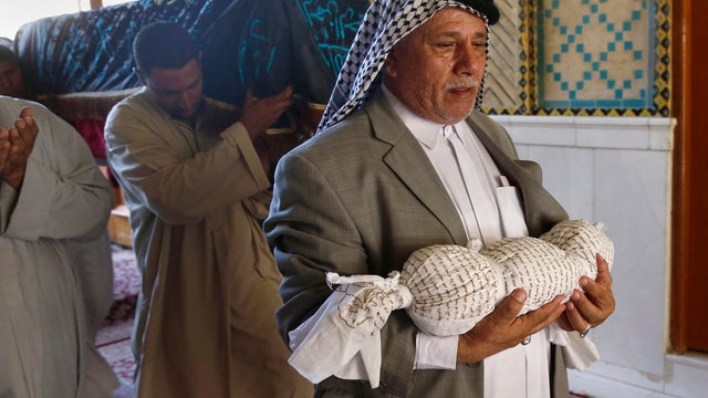 Mourners carry the bodies of Iraqis killed in a car bombing 