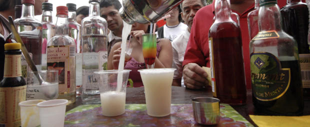 People wait to be served pisco sour - a 