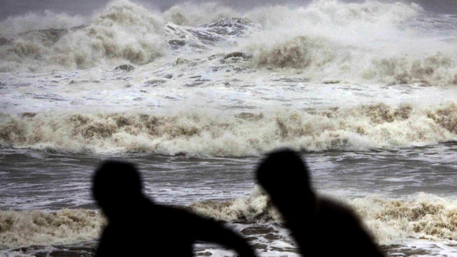 Indian people run for shelter following a cyclone warning at the Bay of Bengal coast in Gopalpur beach in Ganjam district, India, Oct. 12, 2013. 