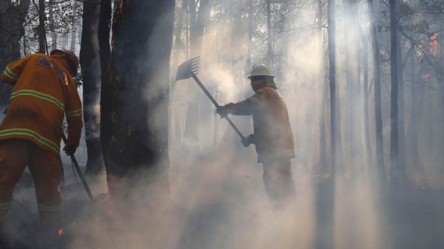 Firefighters mop up and check for reflash after a firestorm swept through a property in Bilpin 