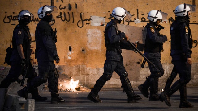 Bahraini riot policemen try to chase anti-regime protesters during clashes following the funeral of Ali Khalil Sabbagh 