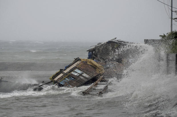 A house is engulfed by the storm surge from Typhoon Haiyan, as it hits Legazpi city 