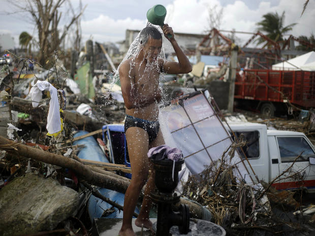 A man takes a shower amid rubble in an area badly affected by Typhoon Haiyan in Tacloban, Philippines, Nov. 13, 2013. 