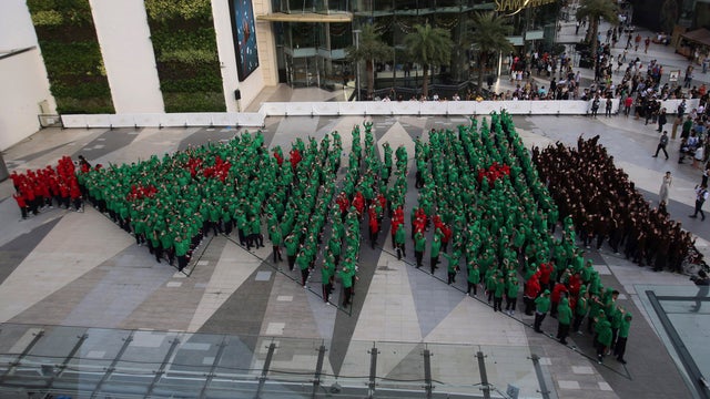 Dressed in red, green and black hoodies, 852 Thai students wave as they break the Guinness World Record for forming the largest human Christmas tree  