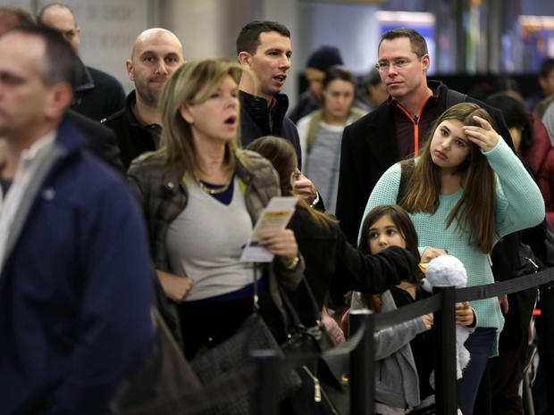 Travelers wait in line to board a flight at LaGuardia Airport in New York Nov. 26, 2013. 