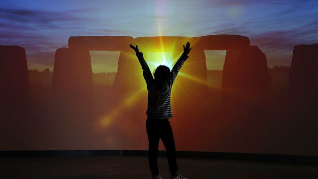 Flora 7, watches the new virtual "Stand in the Stones" experience inside the new Stonehenge visitor center and exhibition 