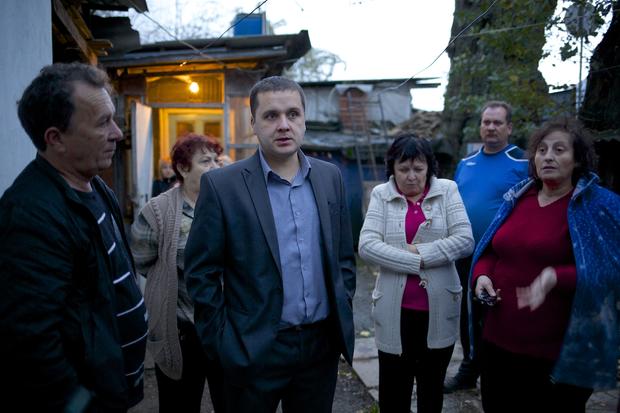 Igor Zarytovsky, center, and his father Vladimir, left, gather  with their neighbors in the yard of the railroad house in the village of Vesyoloye outside Sochi, Russia. 