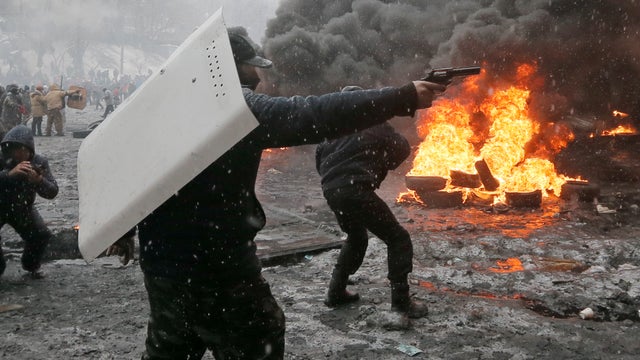 A protester points a handgun during a clash with police in central Kiev 
