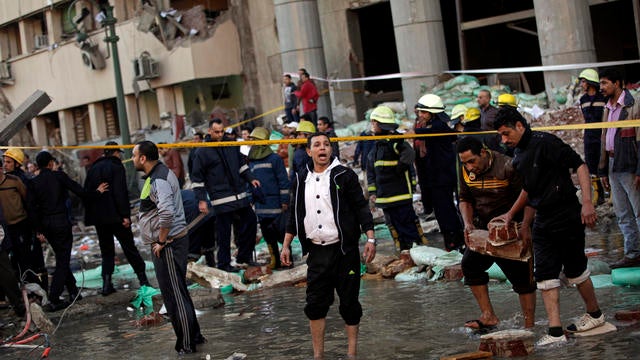 An Egyptian police officer stands in a puddle created when an underground water pipe burst due to a blast at the Egyptian police headquarters in downtown Cairo 