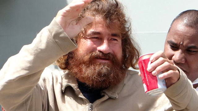 A castaway from Mexico who identified himself as Jose Salvador Alvarenga walks with the help of a Majuro Hospital nurse in Majuro 