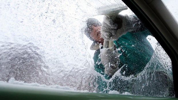 Terry Gillis scrapes ice off his car's window Feb. 12, 2014, in Fort Payne, Ala.