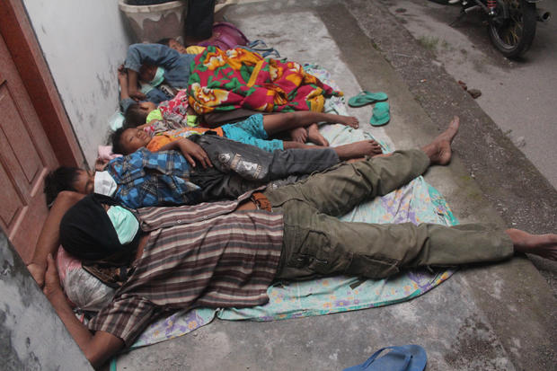 Villagers sleep at a temporary shelter after they were evacuated from their homes 