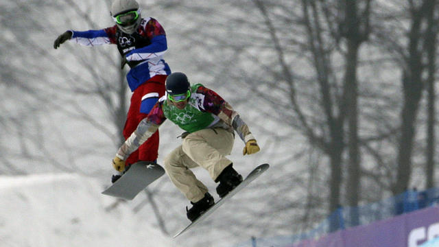 Alex Deibold of the United States, right, and Paul­-Henri de le Rue of France fly over the last jump in the men's snowboard cross final 
