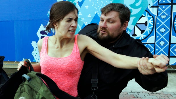Nadezhda Tolokonnikova is pulled away by a Russian security officer after she and fellow members of the punk group Pussy Riot staged a protest performance in Sochi, Russia, Feb. 19, 2014. 