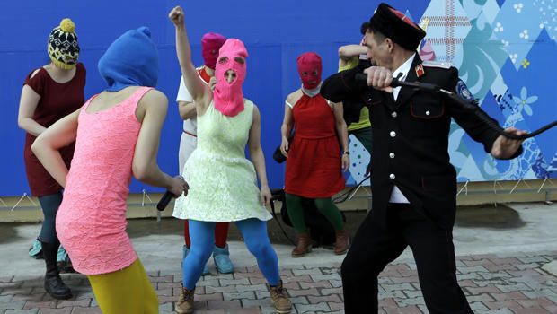 Members of the punk group Pussy Riot, including Nadezhda Tolokonnikova in the blue balaclava and Maria Alekhina in the pink balaclava, are attacked by Cossack militia in Sochi, Russia, Feb. 19, 2014. 