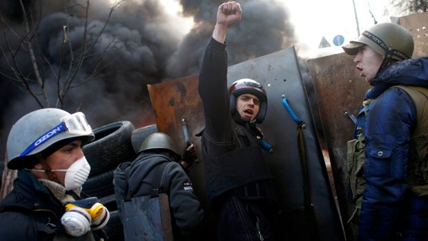 Anti-government protesters shout "Glory to the Ukraine" as they man a barricade at Independence Square in Kiev, Ukraine, Feb. 21, 2014. 