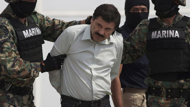 Joaquin "El Chapo" Guzman is escorted to a helicopter in handcuffs by Mexican navy marines 