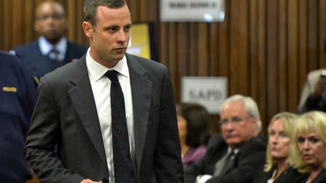 Oscar Pistorius is watched by June Steenkamp, 2nd right, the mother of Reeva Steenkamp, as he arrives for his trial at the high court in Pretoria 