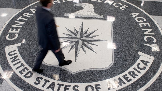 A man crosses the Central Intelligence Agency (CIA) logo in the lobby of CIA Headquarters in Langley, Virginia, on August 14, 2008. 