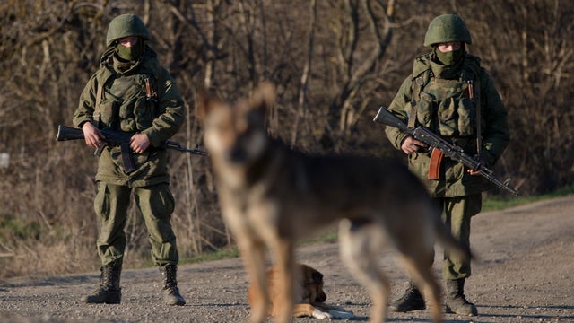 Russian soldiers stand outside the Ukrainian infantry base in Perevalne, Ukraine 