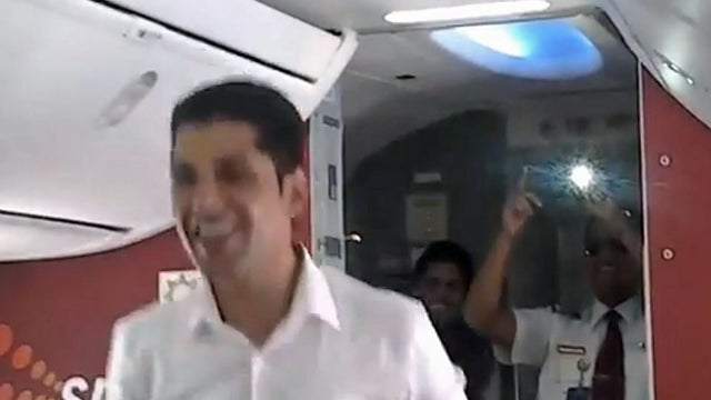 An image from a video posted to YouTube shows a crew member on a SpiceJet flight from Goa to Bangalore, India, performing a Bollywood dance routine as the flight's first officer (at right) videotapes the performance 