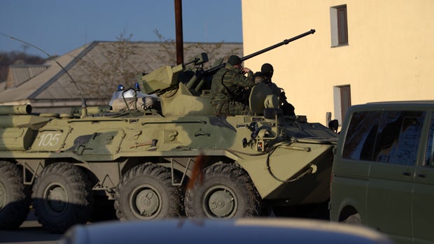 Soldiers in unmarked uniforms sit atop an armored personnel carrier at the gate of the Belbek base near the port city of Sevastopol, Crimea, March 22, 2014. 