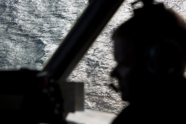 Capt. Peter Moore is silhouetted against the southern Indian Ocean aboard a Royal Australian Air Force AP-3C Orion aircraft during a search operation of the missing Malaysian Airlines Flight MH370 over the south Indian Ocean March 27, 2014. 