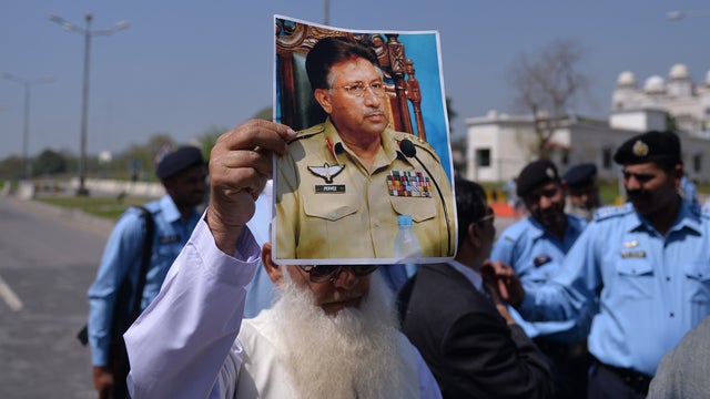 A Pakistani supporter of former military ruler Pervez Musharraf holds a poster bearing his image outside a special court set up to try Musharraf during a hearing in Islamabad 